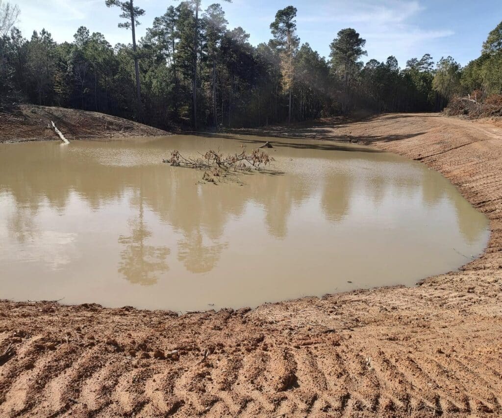 Pond excavation with shaped banks and water in East Texas